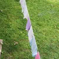 A clothesline with pastel clothes hanging on it.