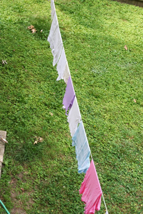 A clothesline with pastel clothes hanging on it.