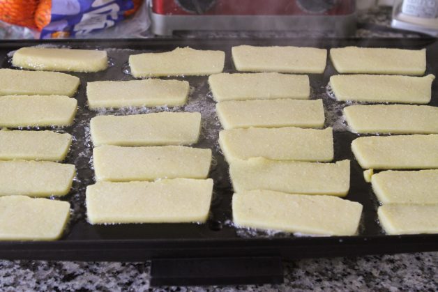 griddle full of cornmeal mush slices