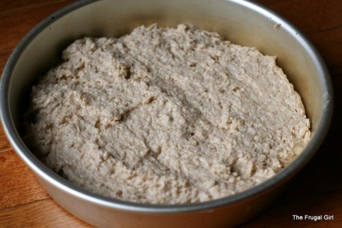 bread dough in a round metal pan.