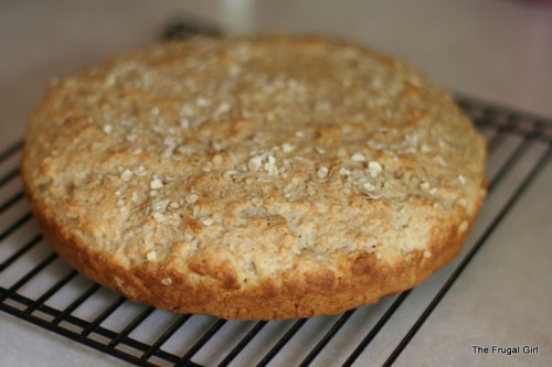 A round loaf of oatmeal bread, cooling.