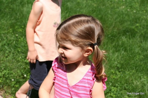 A brown-haired girl in pigtails, looking away from the camera