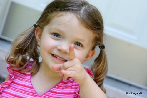 A little girl pointing at the camera.