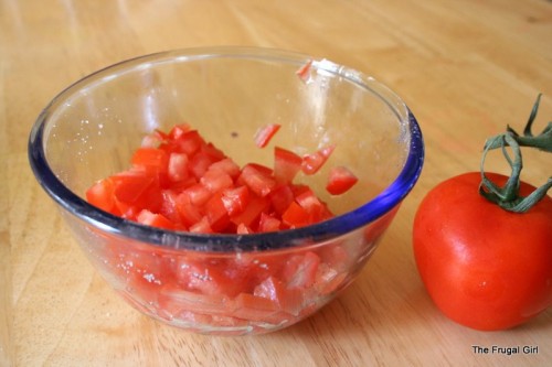 A glass bowl full of chopped tomatoes.