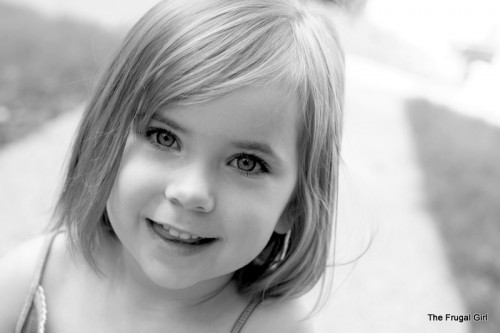 A black and white photo of a little girl with a bob haircut.