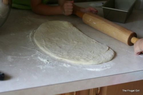 Bread dough rolled out onto a counter.