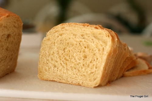 A slice of white sandwich bread on a cutting board.