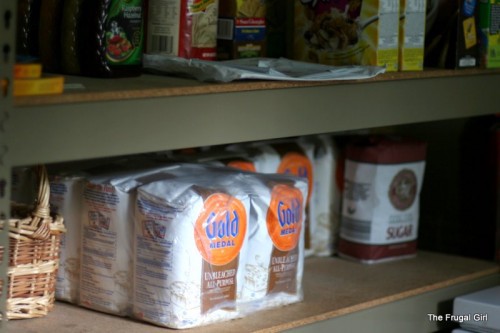 Bags of flour on a pantry shelf.