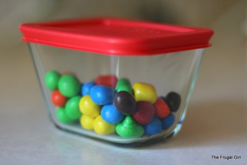 A glass container holding peanut m and ms.