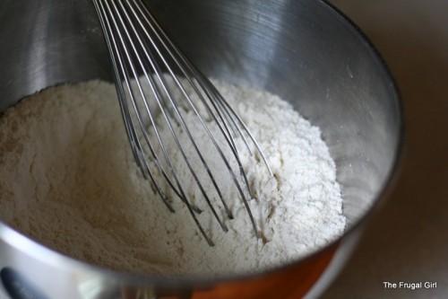 A whisk in a metal bowl.