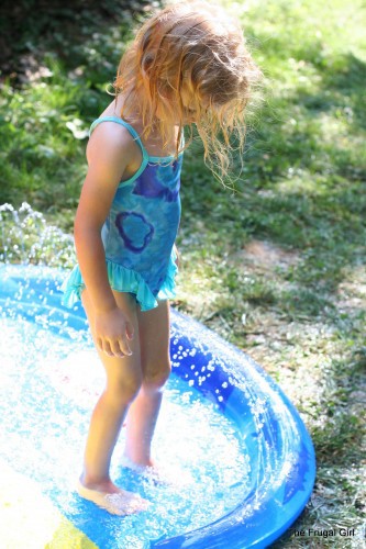 A little girl in a wading pool.
