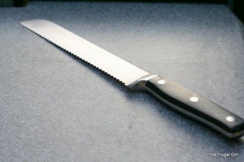 A serrated bread knife on a gray surface.
