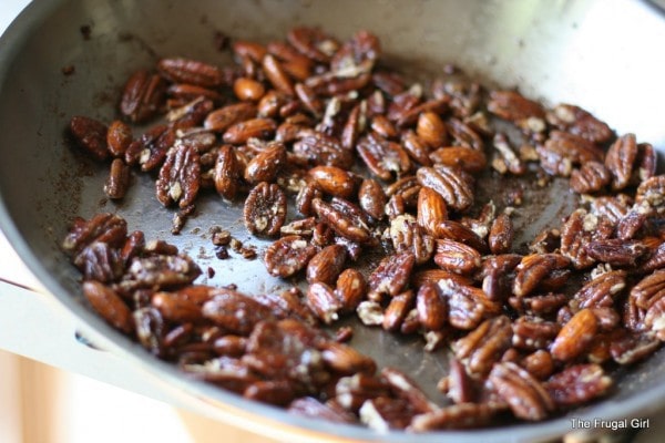 Nuts being tosted in a steel skillet.