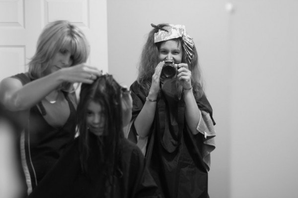 A black and white photo of two women getting their hair done.