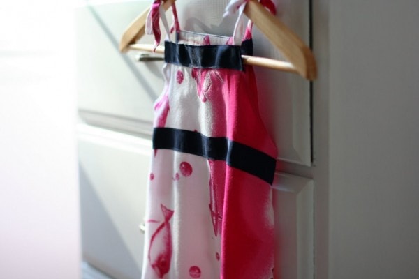 A pink and white dress on a hanger.
