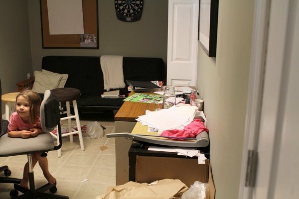 A messy room with green walls.