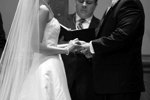 A black and white photo of a couple exchanging wedding vows.
