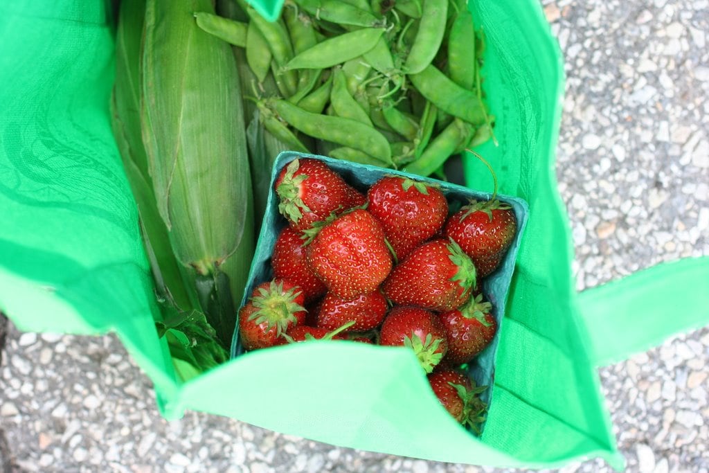 Produce stand purchases in a reusable bag.