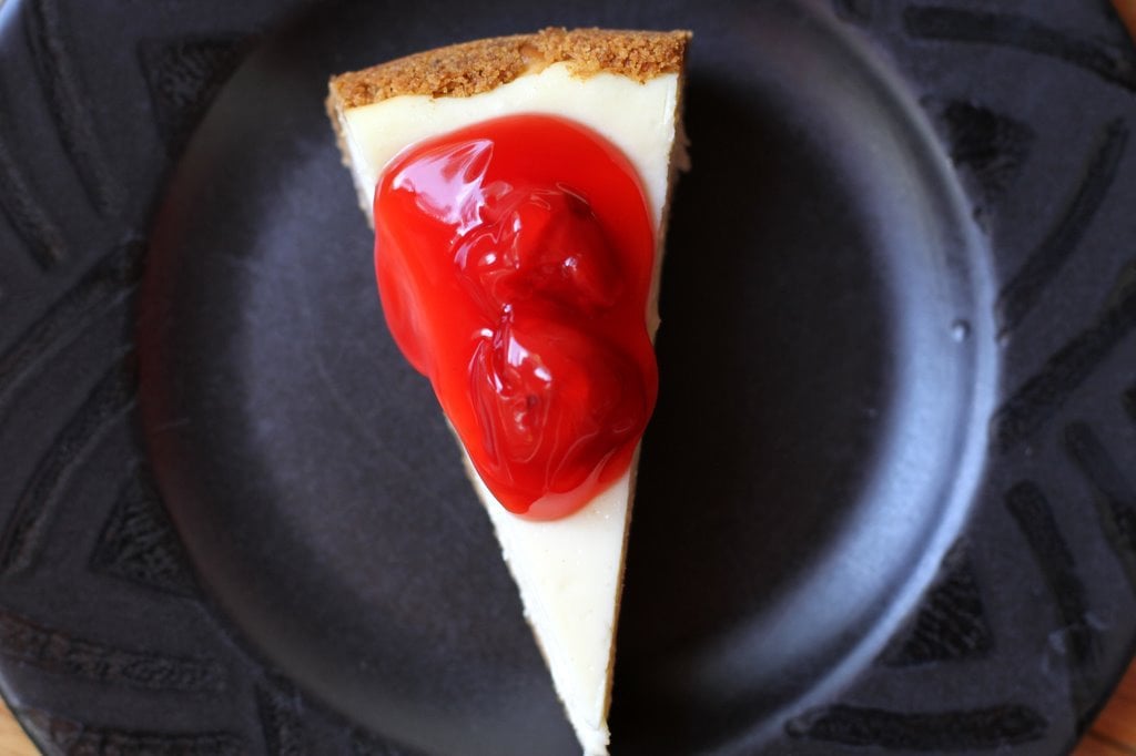 A slice of cherry cheesecake, viewed from above.