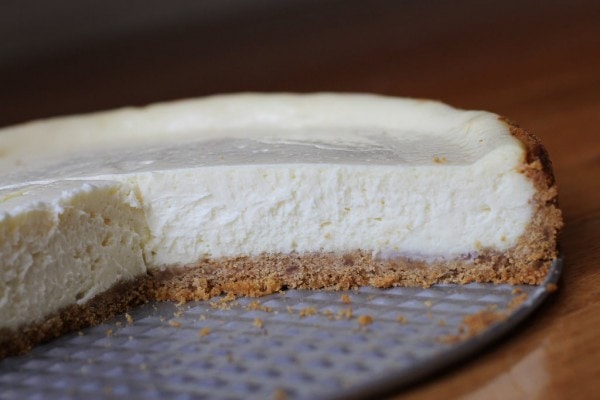 A partially sliced cheesecake.