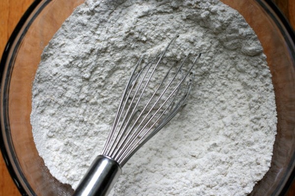A whisk in a bowl of dry ingredients.