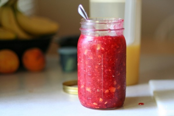 A Mason jar of raspberry peach jam.