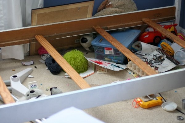 Clutter under a bed frame.