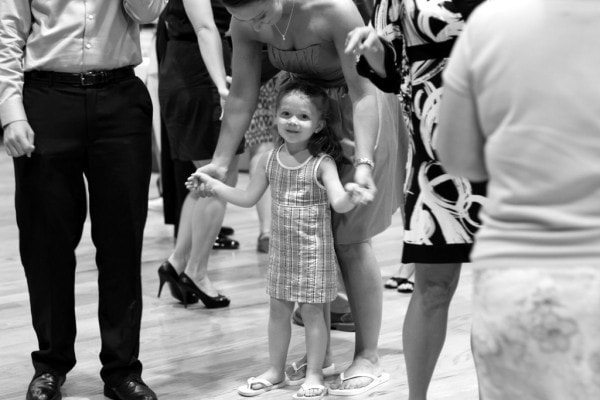 Black and white photo of a little girl in a plaid dress.