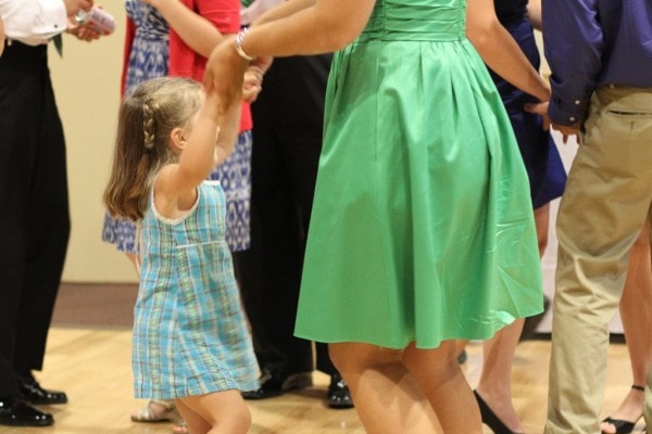 A little girl dancing at a wedding.