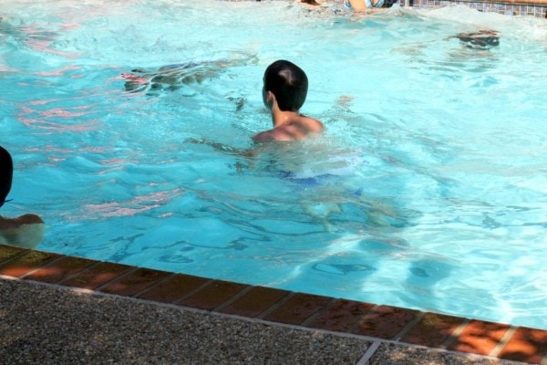 A teen guy in a swimming pool.