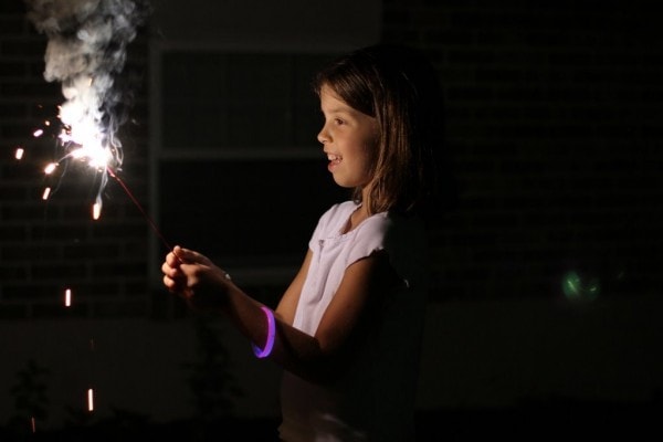 Lisey holding a sparkler at night.