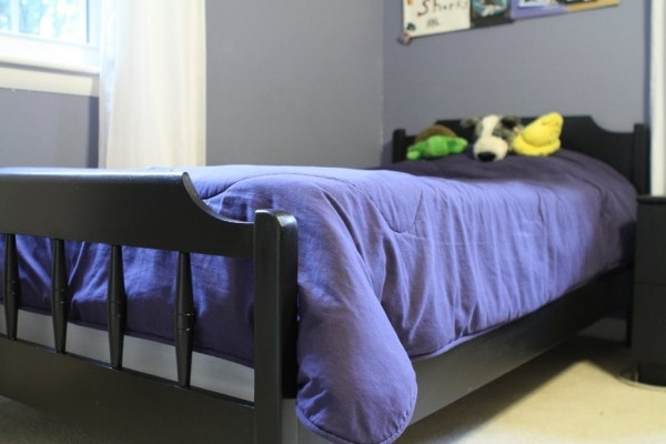 Black twin bed with blue comforter.