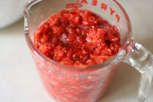Crushed strawberries in a measuring cup.