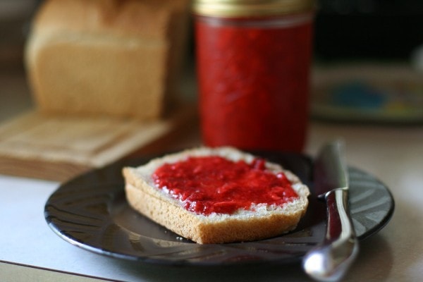 Strawberry jam spread on a slice of bread.