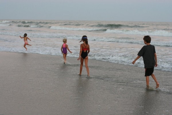 Children walking in the waves.