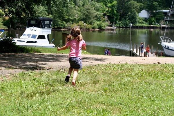 A little girl running toward a pier.