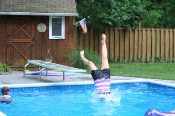 A pair of legs sticking up out of the pool.