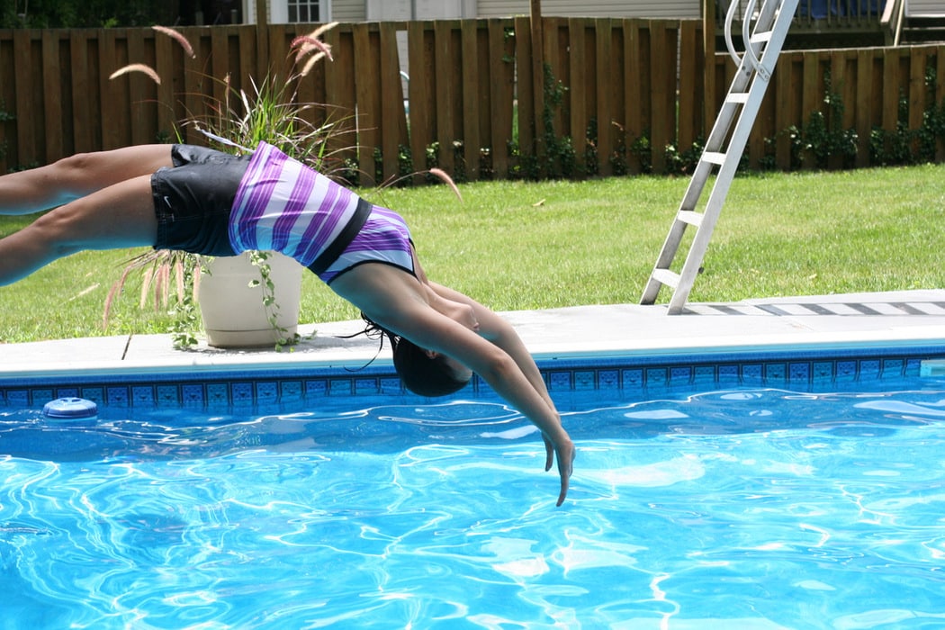 Kristen doing a back dive into a pool.