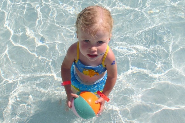 A little girl in a blue bikini.