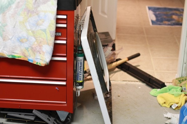 The lid of a washer, propped against a toolbox.