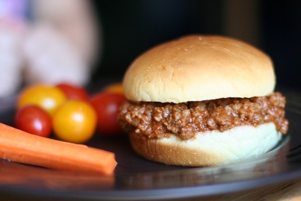 Sloppy joe sandwich with veggies on the side.