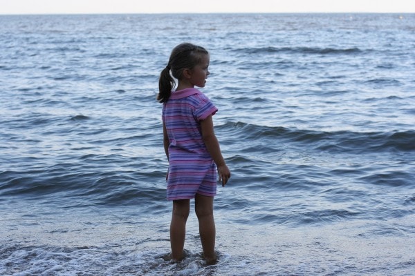 Zoe standing in the water on the beach.