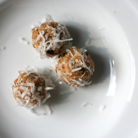 Three no-bake energy balls in a white plate.