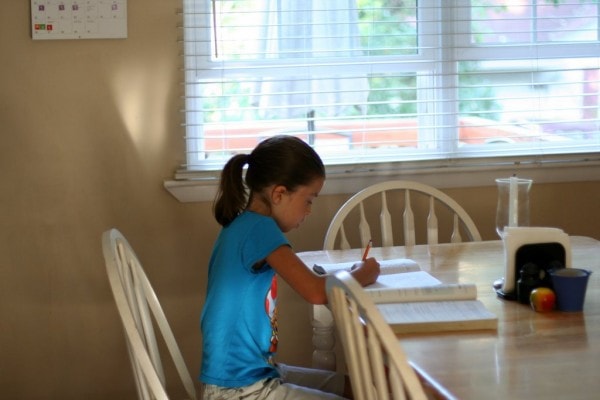 Lisey sitting at the table doing school.