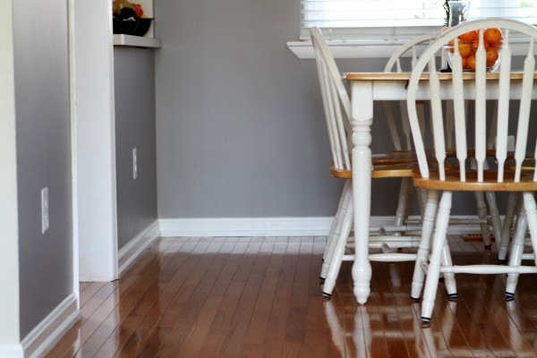 A view of a dining room with gray walls and a white table and chairs.