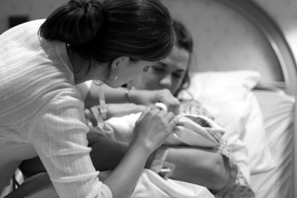 Kristen helping a mom with a newborn.