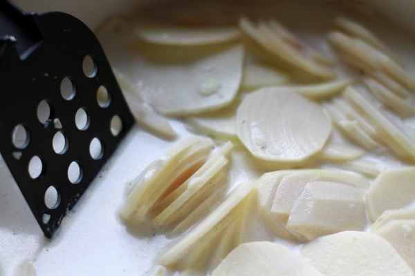 thinly sliced potatoes in a pot.