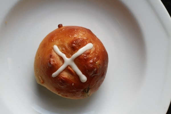 a single frosted hot cross bun.