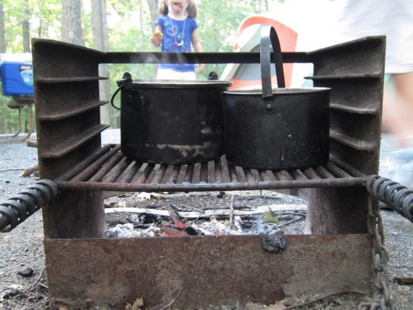 Blackened pots on a fire pit.