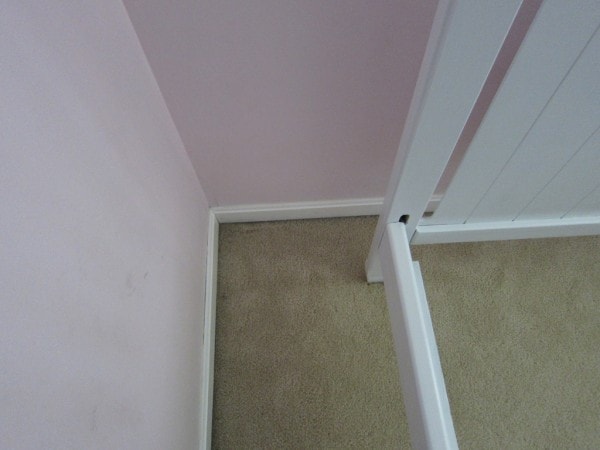 A carpeted corner of a bedroom.